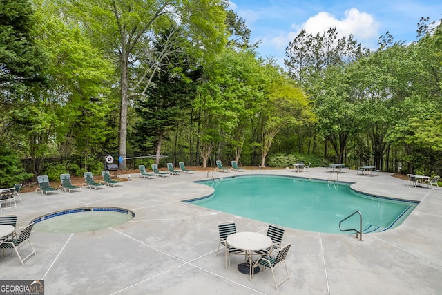 pool with a patio and fence