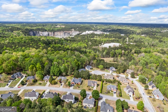 drone / aerial view with a wooded view and a residential view