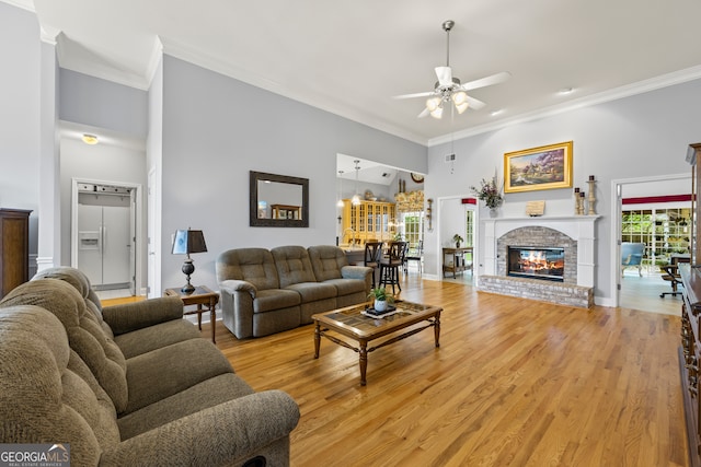 living room featuring light wood-style flooring, ceiling fan, and ornamental molding