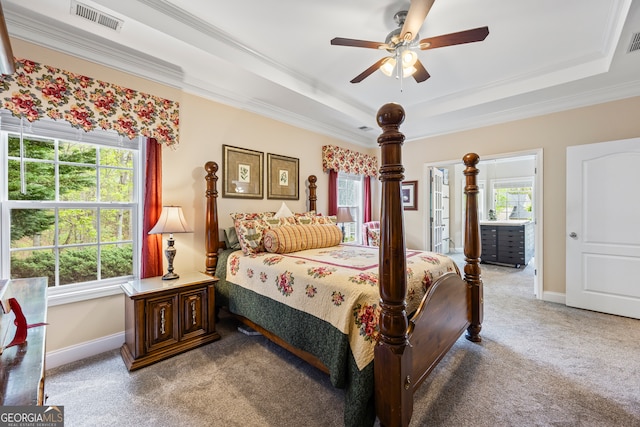 bedroom with visible vents, baseboards, crown molding, a tray ceiling, and carpet flooring