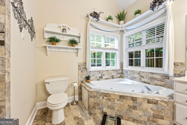 full bathroom featuring toilet, marble finish floor, baseboards, and a tub with jets