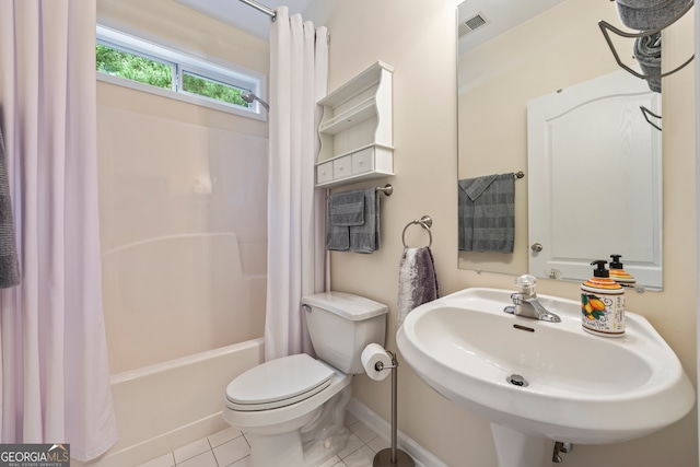 bathroom with visible vents, toilet, a sink, tile patterned floors, and shower / bath combo with shower curtain