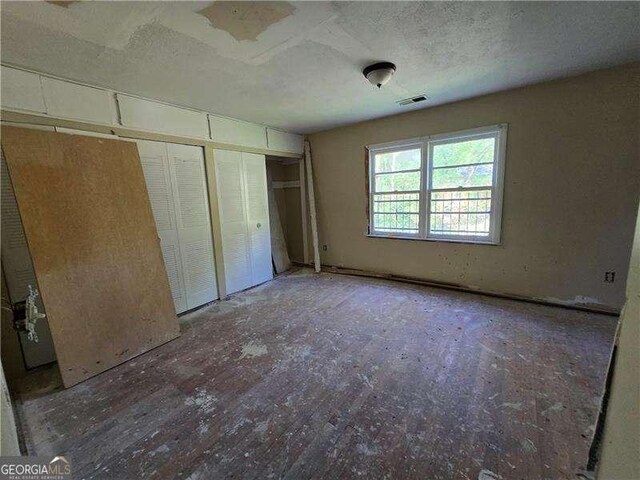 1846 Markone St NW, Atlanta, GA 30318 - unfurnished bedroom featuring a textured ceiling, visible vents, and a closet