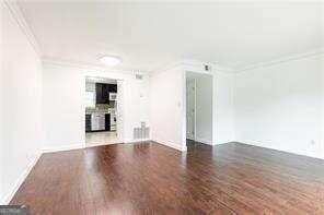 5672 Kingsport Dr Unit 4, Atlanta, GA 30342 - unfurnished living room with ornamental molding and wood finished floors