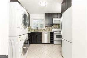 5672 Kingsport Dr Unit 4, Atlanta, GA 30342 - laundry room with stacked washing maching and dryer, laundry area, and light tile patterned flooring