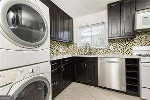 5672 Kingsport Dr Unit 4, Atlanta, GA 30342 - washroom featuring a sink, stacked washer / dryer, and light tile patterned flooring