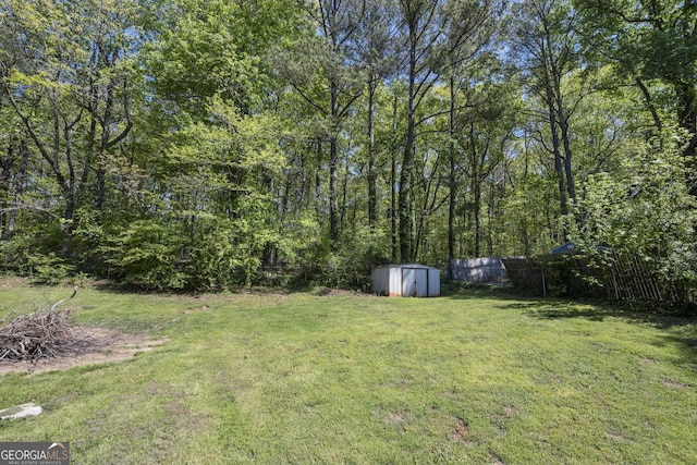 view of yard with fence, an outdoor structure, and a shed