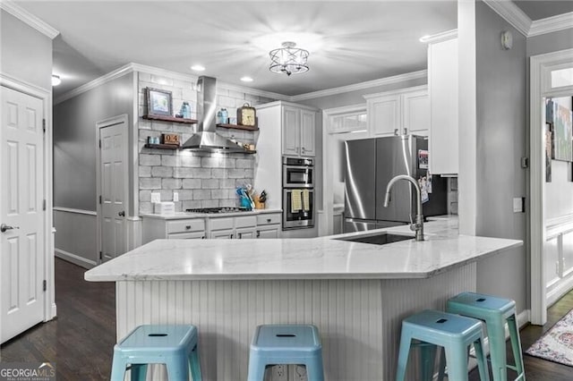 1326 Benbrooke Ln NW, Acworth, GA 30101 - kitchen with wall chimney exhaust hood, tasteful backsplash, a peninsula, appliances with stainless steel finishes, and a sink