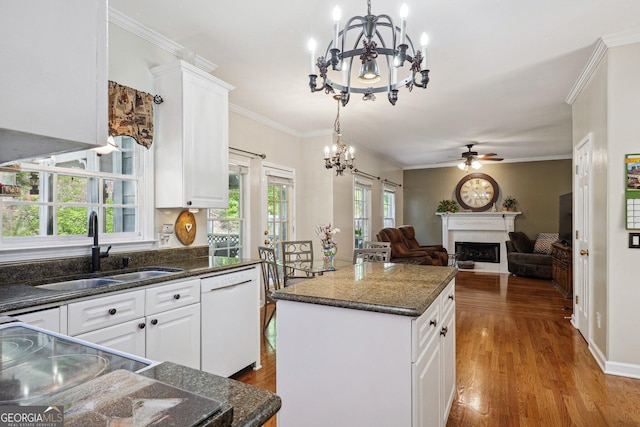 kitchen with a sink, ceiling fan with notable chandelier, a fireplace, dishwasher, and a kitchen island