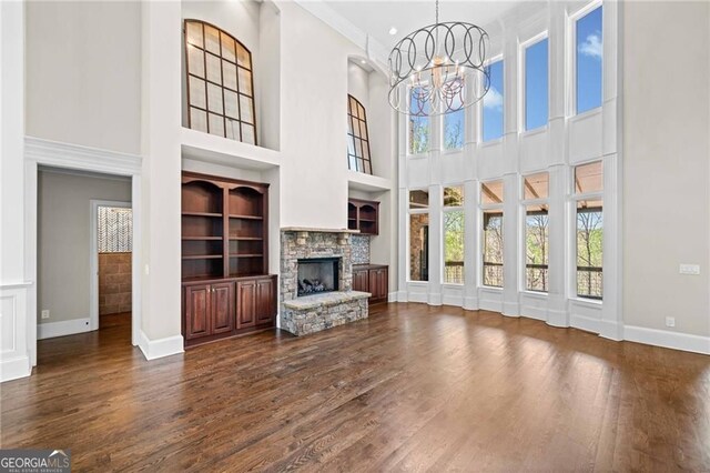 411 River Bluff Ln, Ball Ground, GA 30107 - unfurnished living room featuring a chandelier, a high ceiling, and dark wood finished floors