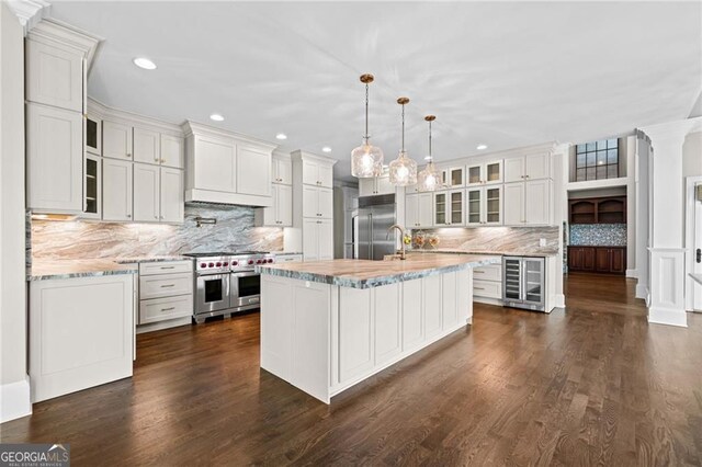 411 River Bluff Ln, Ball Ground, GA 30107 - kitchen featuring white cabinets, high quality appliances, wine cooler, recessed lighting, and backsplash