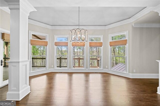 411 River Bluff Ln, Ball Ground, GA 30107 - unfurnished dining area with baseboards, a notable chandelier, decorative columns, crown molding, and wood finished floors