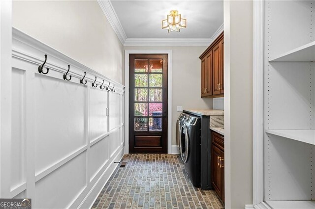 411 River Bluff Ln, Ball Ground, GA 30107 - laundry area with brick patterned floor, a notable chandelier, ornamental molding, cabinet space, and washing machine and clothes dryer