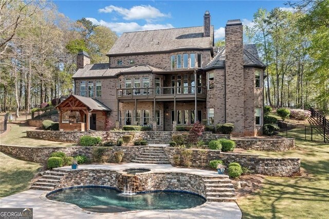 411 River Bluff Ln, Ball Ground, GA 30107 - back of property featuring a patio, fence, an in ground hot tub, brick siding, and a chimney