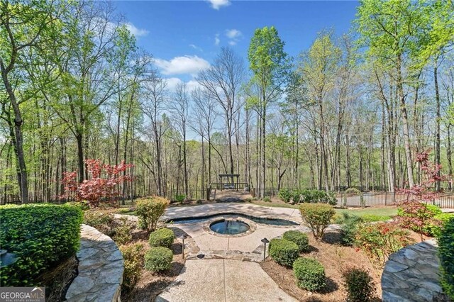 411 River Bluff Ln, Ball Ground, GA 30107 - view of yard with an in ground hot tub, a forest view, and fence