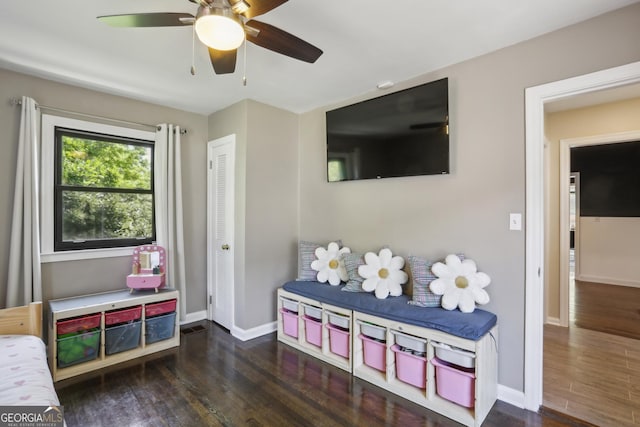 living area with wood finished floors, baseboards, and ceiling fan