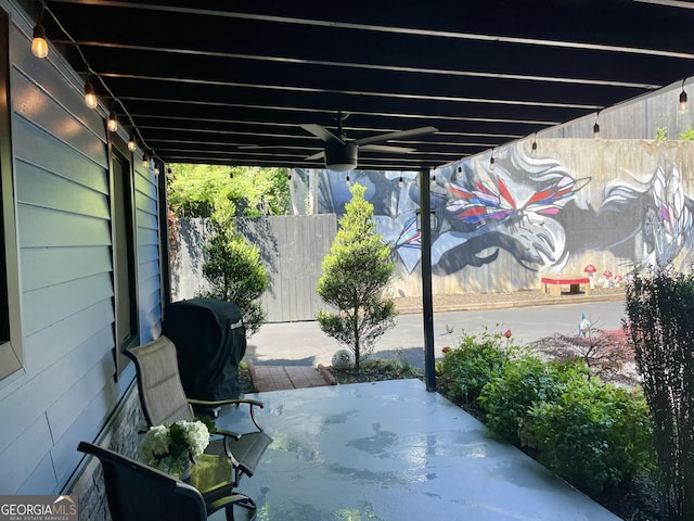 view of patio featuring fence and a grill