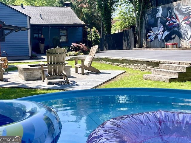 view of pool with a fire pit, a patio, and fence