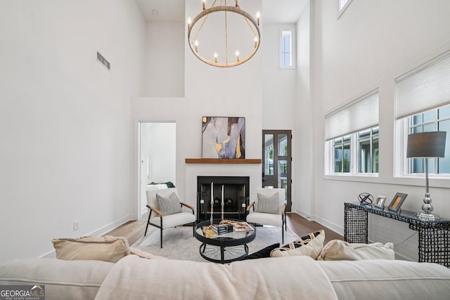135 Channing Ln, Fayetteville, GA 30214 - living room with a chandelier, a high ceiling, a fireplace, and wood finished floors