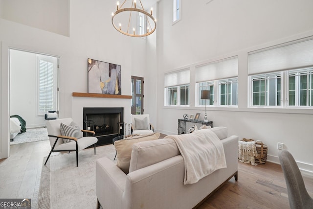135 Channing Ln, Fayetteville, GA 30214 - living area featuring wood finished floors, a chandelier, a fireplace, and a high ceiling