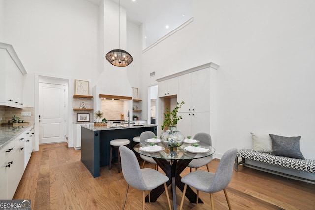 135 Channing Ln, Fayetteville, GA 30214 - dining space with light wood-style floors, a high ceiling, and a chandelier