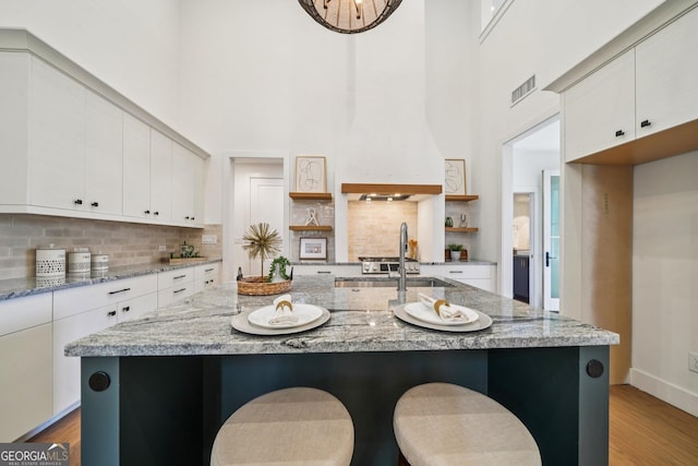 135 Channing Ln, Fayetteville, GA 30214 - kitchen featuring open shelves, light wood-type flooring, white cabinetry, decorative backsplash, and a high ceiling