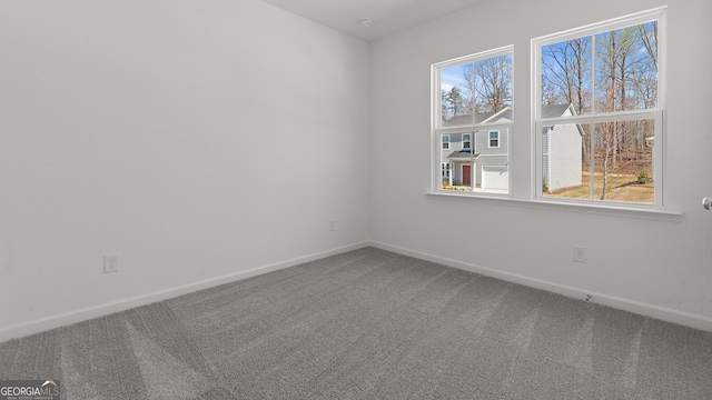 empty room with baseboards and carpet