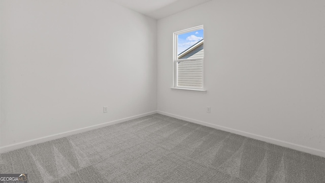 unfurnished room with baseboards and carpet