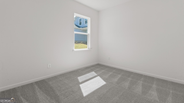 carpeted spare room featuring baseboards