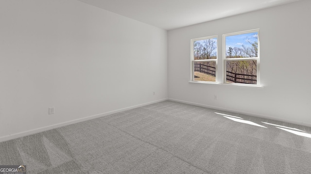 carpeted spare room featuring baseboards