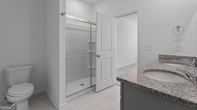 bathroom featuring a sink, tile patterned flooring, toilet, and a stall shower