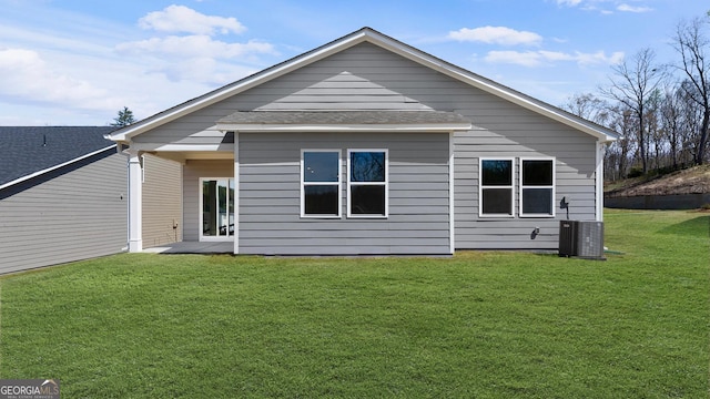 back of property featuring central AC unit and a lawn