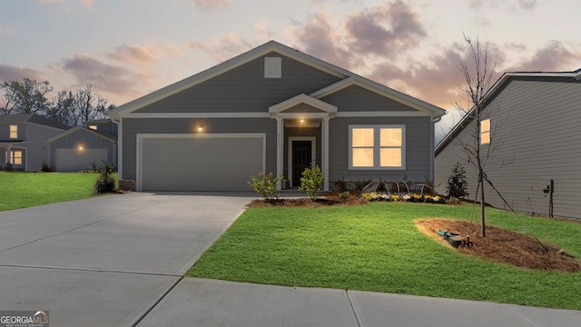 view of front of house with an attached garage, concrete driveway, and a lawn