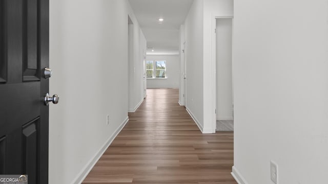 corridor with recessed lighting, baseboards, and wood finished floors
