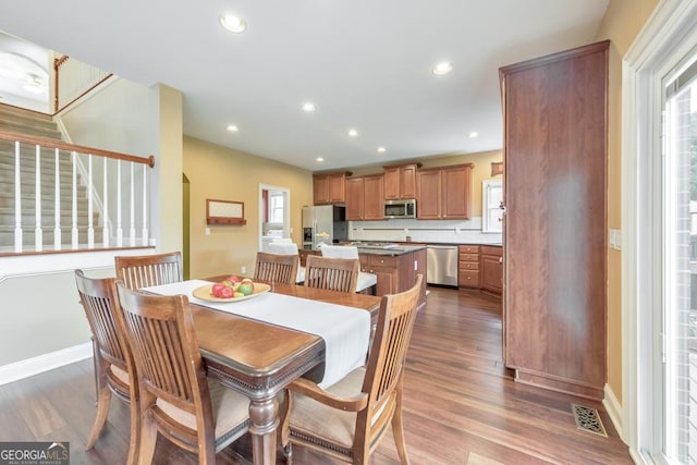 dining space featuring baseboards, recessed lighting, dark wood-style flooring, and stairway