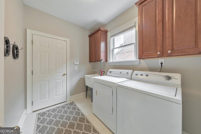 laundry room with cabinet space, separate washer and dryer, baseboards, and light tile patterned floors