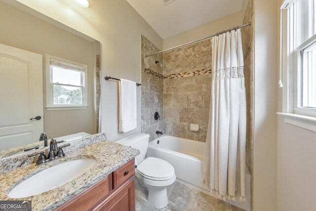 bathroom featuring plenty of natural light, shower / bath combo with shower curtain, toilet, and vanity