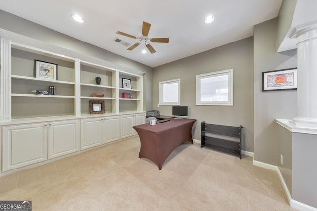 office space with visible vents, light carpet, baseboards, ceiling fan, and ornate columns