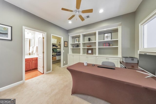 office with ceiling fan, light colored carpet, baseboards, and visible vents
