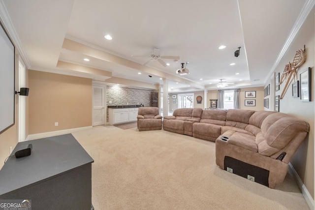 living area featuring crown molding, light carpet, ceiling fan, recessed lighting, and a raised ceiling