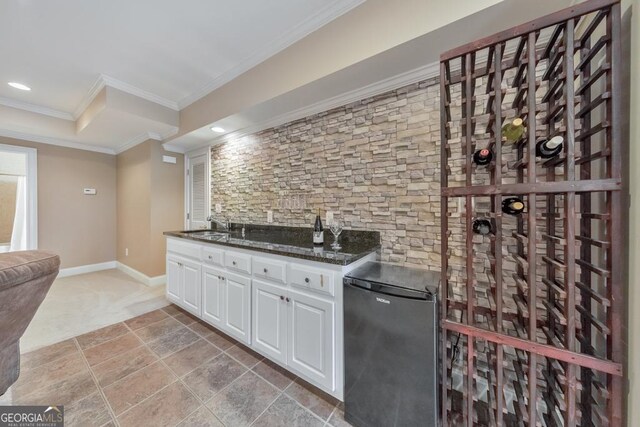 wine room featuring a sink, indoor wet bar, ornamental molding, light carpet, and recessed lighting