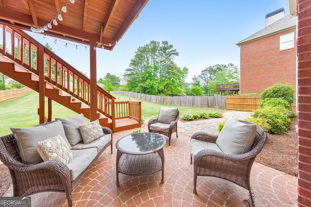 view of patio with a fenced backyard, stairs, and an outdoor living space