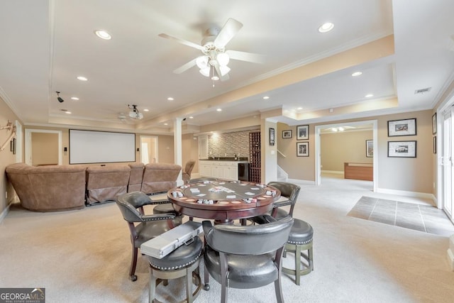 dining space featuring crown molding, a tray ceiling, and light carpet