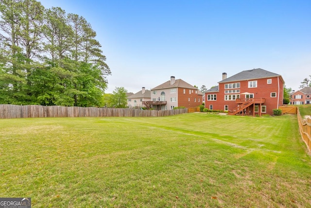 view of yard with stairway, a residential view, and a fenced backyard