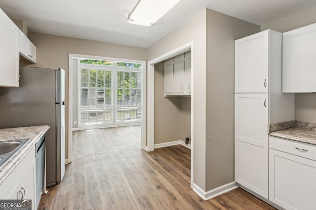 kitchen featuring light wood-style floors, baseboards, white cabinets, and appliances with stainless steel finishes