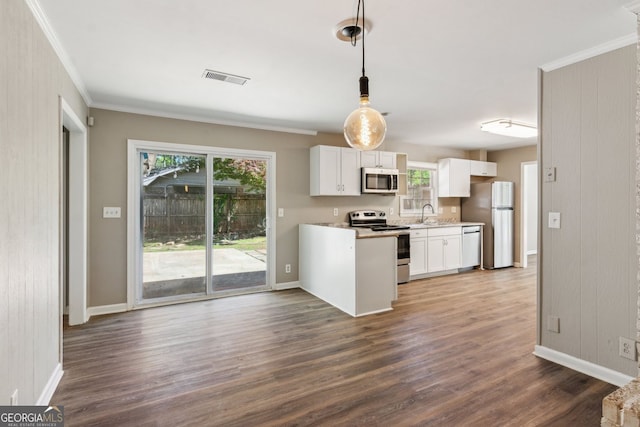 kitchen featuring a sink, dark wood finished floors, stainless steel appliances, white cabinetry, and visible vents