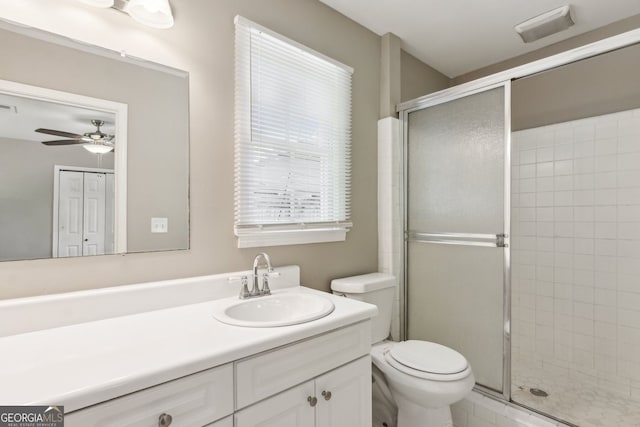 bathroom featuring vanity, ceiling fan, toilet, and a shower stall