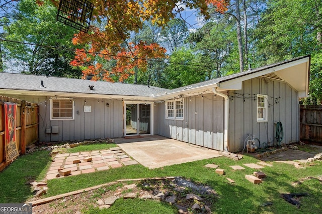 rear view of property featuring a patio, a fenced backyard, board and batten siding, and a lawn