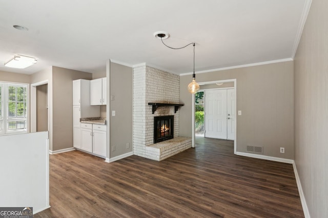 unfurnished living room featuring baseboards, dark wood finished floors, visible vents, and a fireplace