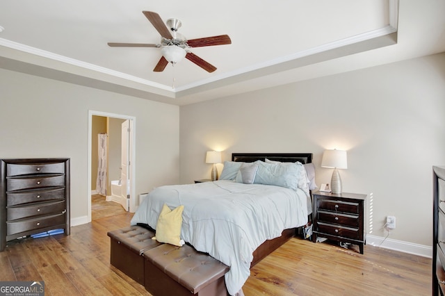 890 Crescent Ln, Griffin, GA 30224 - bedroom with a raised ceiling, light wood-style flooring, crown molding, a ceiling fan, and connected bathroom